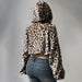 Leopard print hoodie worn by a person on a gray background