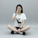 Person wearing a white t-shirt with a black deer graphic sitting on the floor.