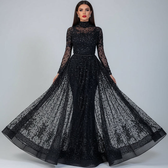 Black sheer evening gown with long sleeves and a flowing skirt on a neutral background